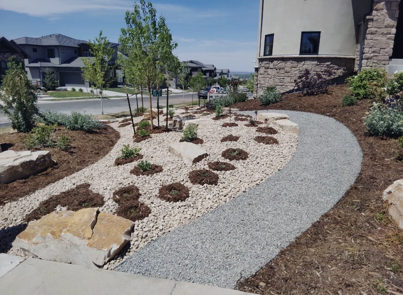 Completed residential landscape with stone, gravel, mulch and new plantings